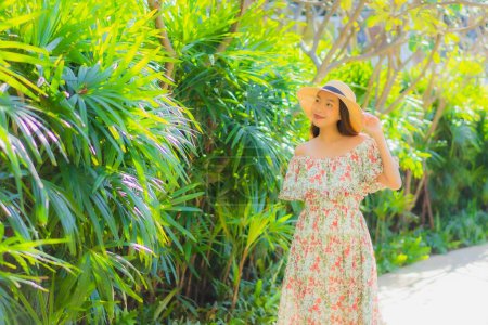 Foto de Retrato hermosa joven asiática mujer caminando con feliz disfrutar alrededor de jardín al aire libre vista - Imagen libre de derechos