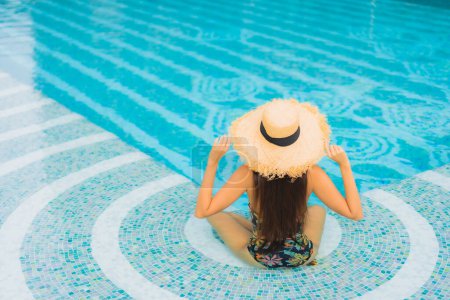 Téléchargez les photos : Portrait belle jeune femme asiatique se détendre sourire autour de la piscine extérieure dans la station hôtelière en vacances de voyage loisirs - en image libre de droit