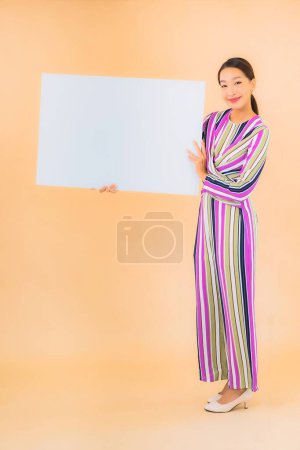 Photo for Portrait beautiful young asian woman show empty white billboard on color background - Royalty Free Image