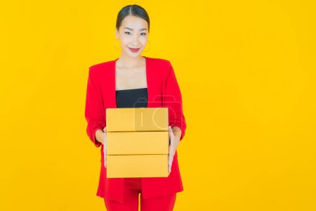Foto de Retrato hermosa joven mujer asiática con caja listo para el envío en el fondo de color - Imagen libre de derechos