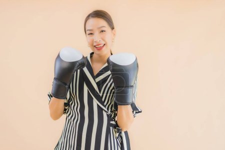 Téléchargez les photos : Portrait belle jeune femme asiatique avec boxe sur fond brun - en image libre de droit