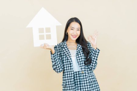 Photo for Portrait beautiful young asian woman with house or home paper sign on color background - Royalty Free Image