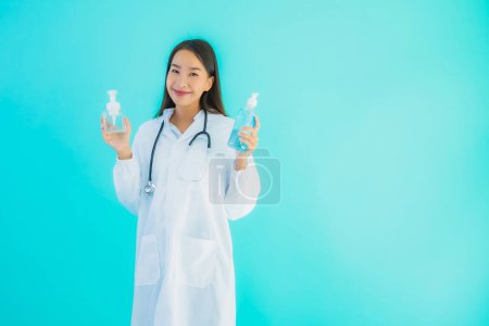 Photo for Portrait beautiful young asian doctor woman with gel alcohol for clean hand and protect from covid19 or coronavirus on blue isolated background - Royalty Free Image