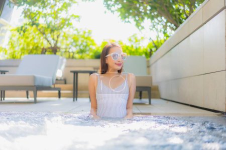 Téléchargez les photos : Portrait belle jeune femme asiatique sourire détendre loisirs autour de la piscine pour les vacances - en image libre de droit