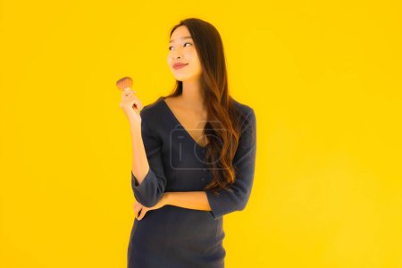 Foto de Retrato hermosa joven asiática mujer con maquillaje cepillo en amarillo aislado fondo - Imagen libre de derechos
