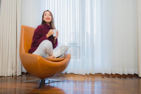 Photo for Portrait beautiful young asian woman smile relax on sofa in living room interior - Royalty Free Image