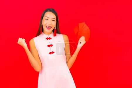 Téléchargez les photos : Portrait belle jeune femme asiatique avec enveloppe rouge lettre sur fond rouge - en image libre de droit