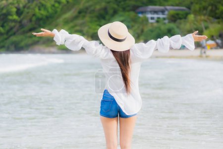 Téléchargez les photos : Portrait belle jeune femme asiatique se détendre sourire autour de la plage mer océan en vacances voyage vacances - en image libre de droit