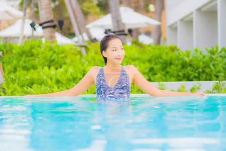 Photo for Portrait beautiful young asian woman relax leisure around outdoor swimming pool with sea ocean beach - Royalty Free Image