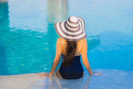 Téléchargez les photos : Portrait belle jeune femme asiatique se détendre autour de la piscine dans la station de l'hôtel pour les loisirs en vacances - en image libre de droit
