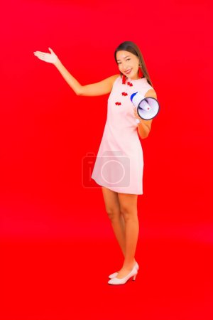 Photo for Portrait beautiful young asian woman with megaphone on red isolated background - Royalty Free Image