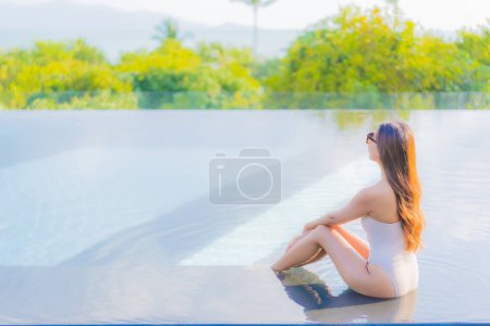 Photo for Portrait beautiful young asian woman enjoy around outdoor swimming pool with sea ocean view - Royalty Free Image