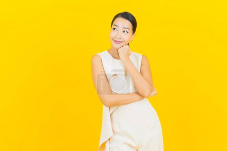 Photo for Portrait beautiful young asian woman smile with action on yellow color background - Royalty Free Image