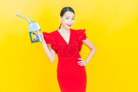 Photo for Portrait beautiful young asian woman feul gas pump on color background - Royalty Free Image