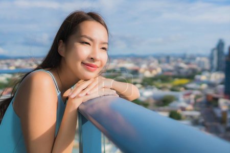 Téléchargez les photos : Portrait belle jeune femme asiatique autour du balcon avec vue extérieure - en image libre de droit