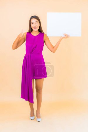 Foto de Retrato hermosa joven asiática mujer con vacío blanco cartel en color de fondo - Imagen libre de derechos
