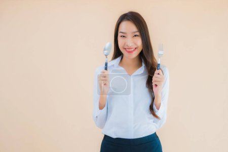 Téléchargez les photos : Portrait belle jeune femme d'affaires asiatique avec cuillère et fourchette prête à manger - en image libre de droit
