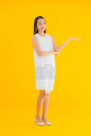 Photo for Portrait beautiful young asian woman in action on yellow isolated background - Royalty Free Image