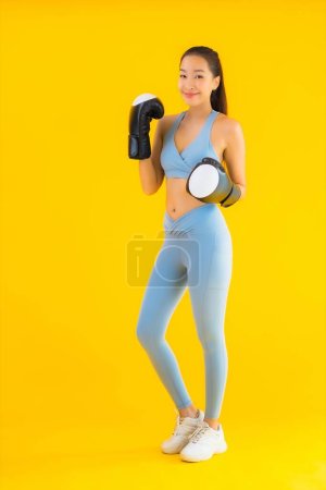 Photo for Portrait beautiful young asian woman wear sportwear with boxing on yellow isolated background - Royalty Free Image