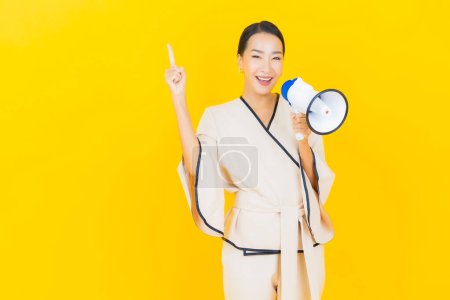 Photo for Portrait beautiful young business asian woman with megaphone for communication on yellow background - Royalty Free Image