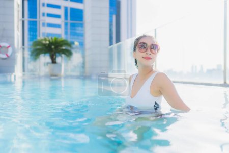 Foto de Retrato hermosa joven mujer asiática relajarse ocio alrededor de la piscina en viajes de vacaciones - Imagen libre de derechos