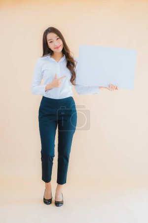 Téléchargez les photos : Portrait belle jeune femme d'affaires asiatique montrer bannière panneau d'affichage vide blanc sur fond de couleur isolé - en image libre de droit