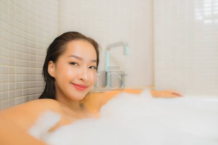 Photo for Portrait beautiful young asian woman relax smile in bathtub at bathroom interior - Royalty Free Image