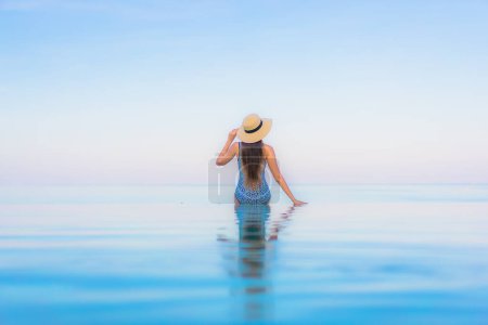 Photo for Portrait beautiful young asian woman relax smile leisure around outdoor swimming pool nearly sea beach in Travel vacation - Royalty Free Image