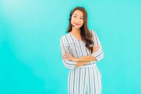 Téléchargez les photos : Portrait belle jeune femme asiatique centre d'appel sur fond bleu isolé - en image libre de droit