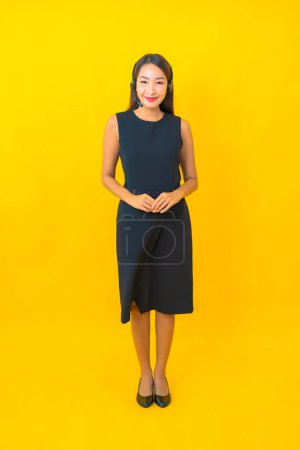 Photo for Portrait beautiful young asian business woman with headset call center customer care on yellow background - Royalty Free Image