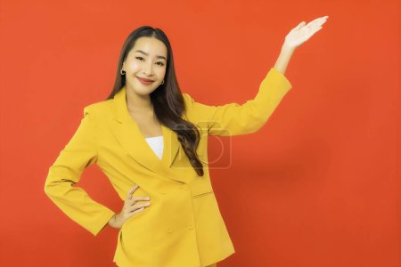 Foto de Retrato hermosa joven negocio asiático mujer sonrisa con acción en rojo aislado fondo - Imagen libre de derechos