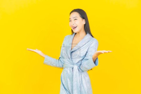 Foto de Retrato hermosa joven mujer asiática sonrisa con acción sobre fondo de color amarillo - Imagen libre de derechos