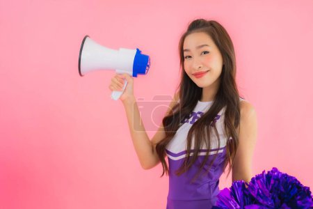 Photo for Portrait beautiful young asian woman cheerleader smile happy with megaphone on isolated pink background - Royalty Free Image