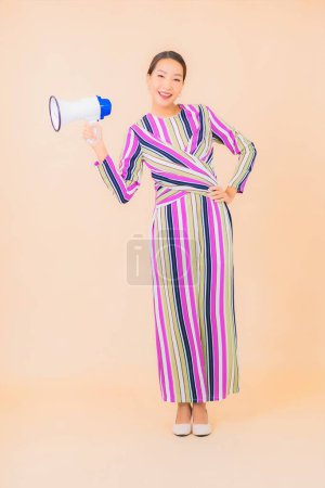 Téléchargez les photos : Portrait belle jeune femme asiatique avec mégaphone pour la communication sur fond isolé couleur - en image libre de droit