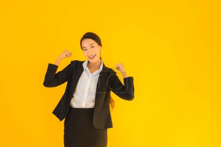 Téléchargez les photos : Beau portrait jeune entreprise asiatique femme heureux sourire dans beaucoup action sur jaune isolé fond - en image libre de droit