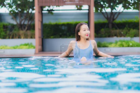 Foto de Retrato hermosa joven asiática mujer relajarse sonrisa ocio alrededor al aire libre piscina en hotel resort - Imagen libre de derechos