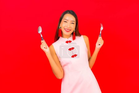 Photo for Portrait beautiful young asian woman with spoon and fork on isolated red background - Royalty Free Image