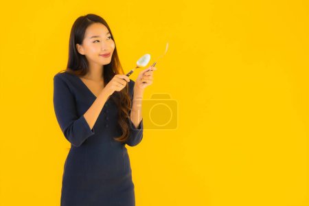Photo for Portrait beautiful young asian woman with spoon and fork ready for eat on yellow isolated background - Royalty Free Image