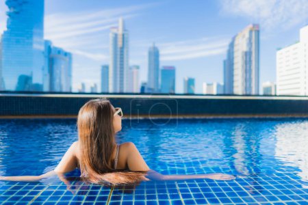 Foto de Retrato hermosa joven mujer asiática relajarse ocio disfrutar alrededor de piscina al aire libre en vacaciones - Imagen libre de derechos