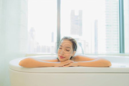 Photo for Portrait beautiful young asian woman smile relax in bathtub interior of bathroom - Royalty Free Image