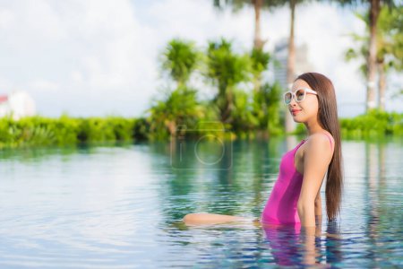 Foto de Retrato hermosa joven mujer asiática relajarse disfrutar alrededor de la piscina al aire libre en vacaciones - Imagen libre de derechos