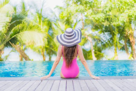 Téléchargez les photos : Portrait belle jeune femme asiatique sourire se détendre autour de la piscine extérieure en hôtel de villégiature en voyage vacances - en image libre de droit