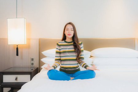 Foto de Retrato hermosa joven mujer asiática meditación en la cama en el interior del dormitorio - Imagen libre de derechos