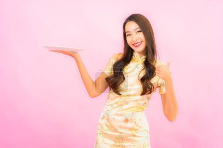 Photo for Portrait beautiful young asian woman with plate on pink color background - Royalty Free Image