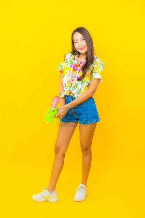 Foto de Retrato hermosa joven asiática mujer usar colorido camisa con agua pistola para sonkran festival - Imagen libre de derechos