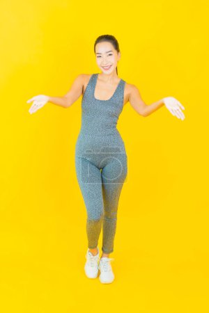 Téléchargez les photos : Portrait belle jeune femme asiatique avec des vêtements de sport prêt pour l'exercice sur fond jaune - en image libre de droit