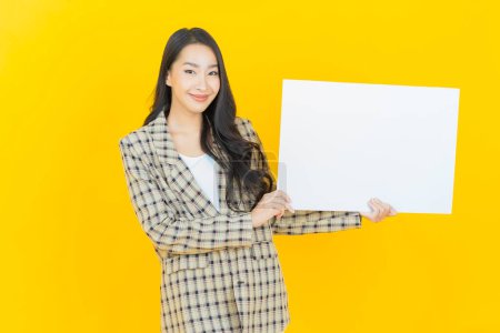 Photo for Portrait beautiful young asian woman with empty white billboard on color background - Royalty Free Image