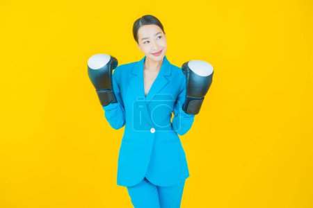 Foto de Retrato hermosa joven asiática mujer con guante de boxeo en color de fondo - Imagen libre de derechos