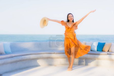 Foto de Retrato hermosa joven asiática mujer feliz sonrisa alrededor de mar océano playa y azul cielo para vacaciones de ocio - Imagen libre de derechos