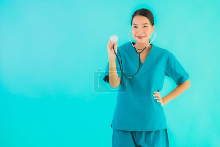 Foto de Retrato hermosa joven asiática médico mujer feliz sonrisa para el trabajo en hospital y clínica en azul aislado fondo - Imagen libre de derechos